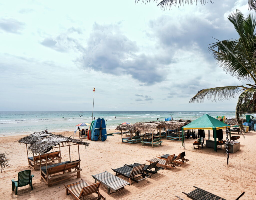 Sunbeds and thatched shades on the sand above the sea