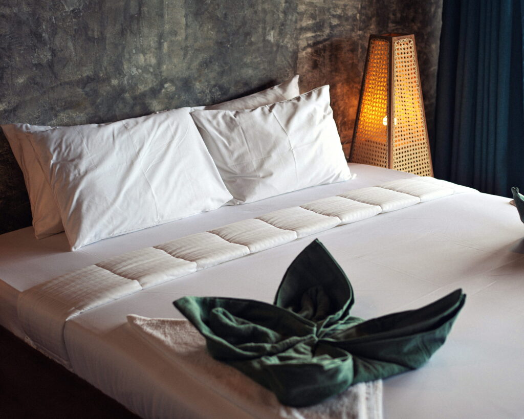 Towel folded into a leaf on a white bed
