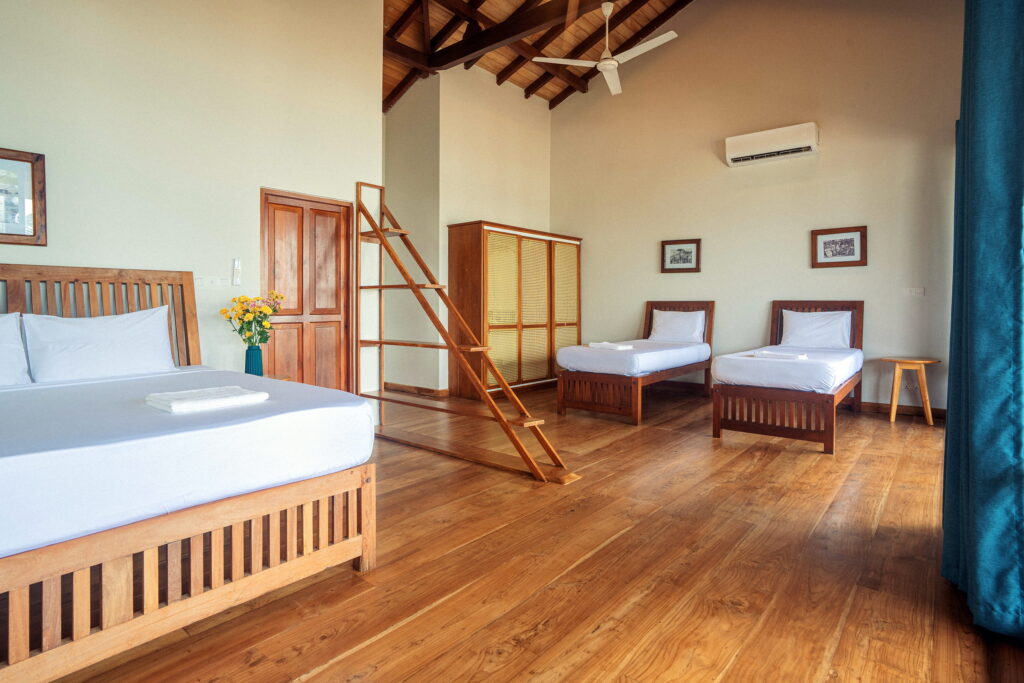 Family room with a king bed and two single beds on a teak floor