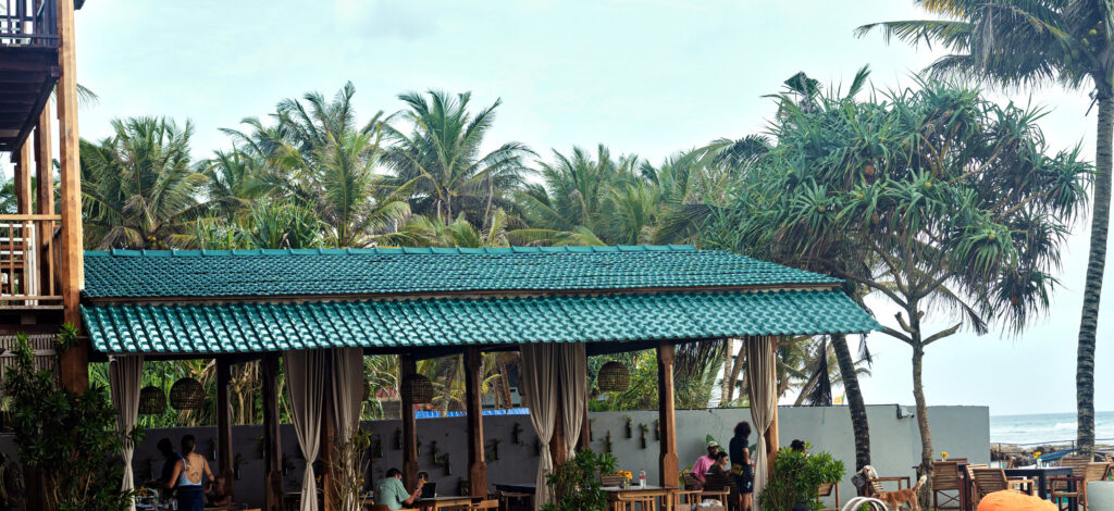The restaurant pavilion with its green tiled roof, teak tables and the sea beyond